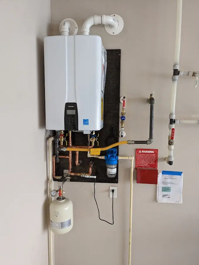 Professional plumber installing copper piping in a Lenoir home